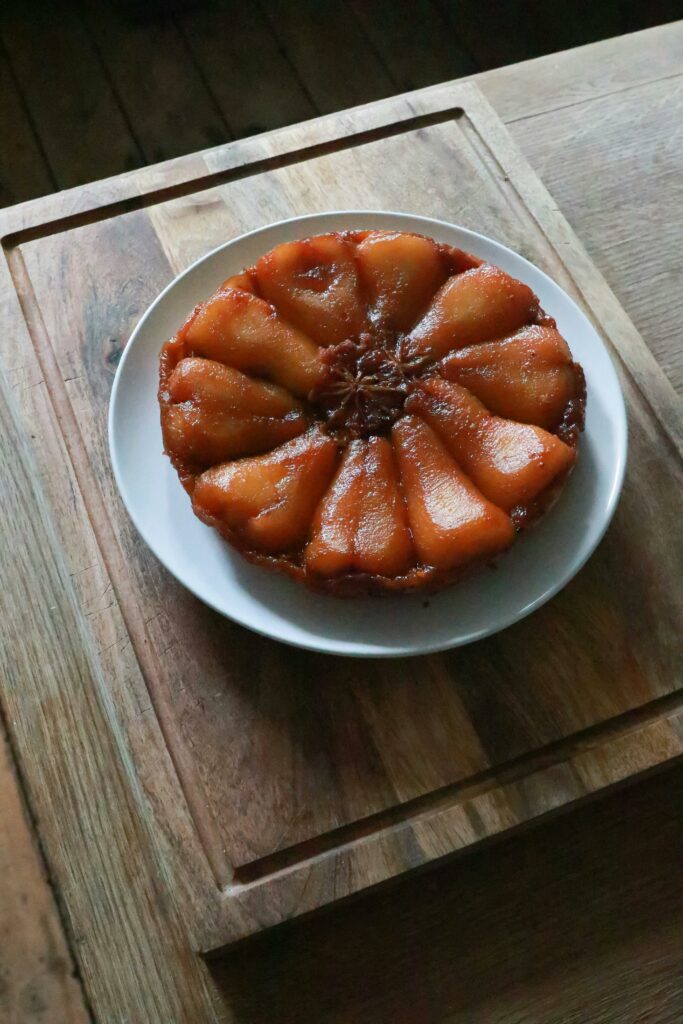 A homemade pear tarte tatin on a ceramic plate, showcasing its appetizing caramelized pears.