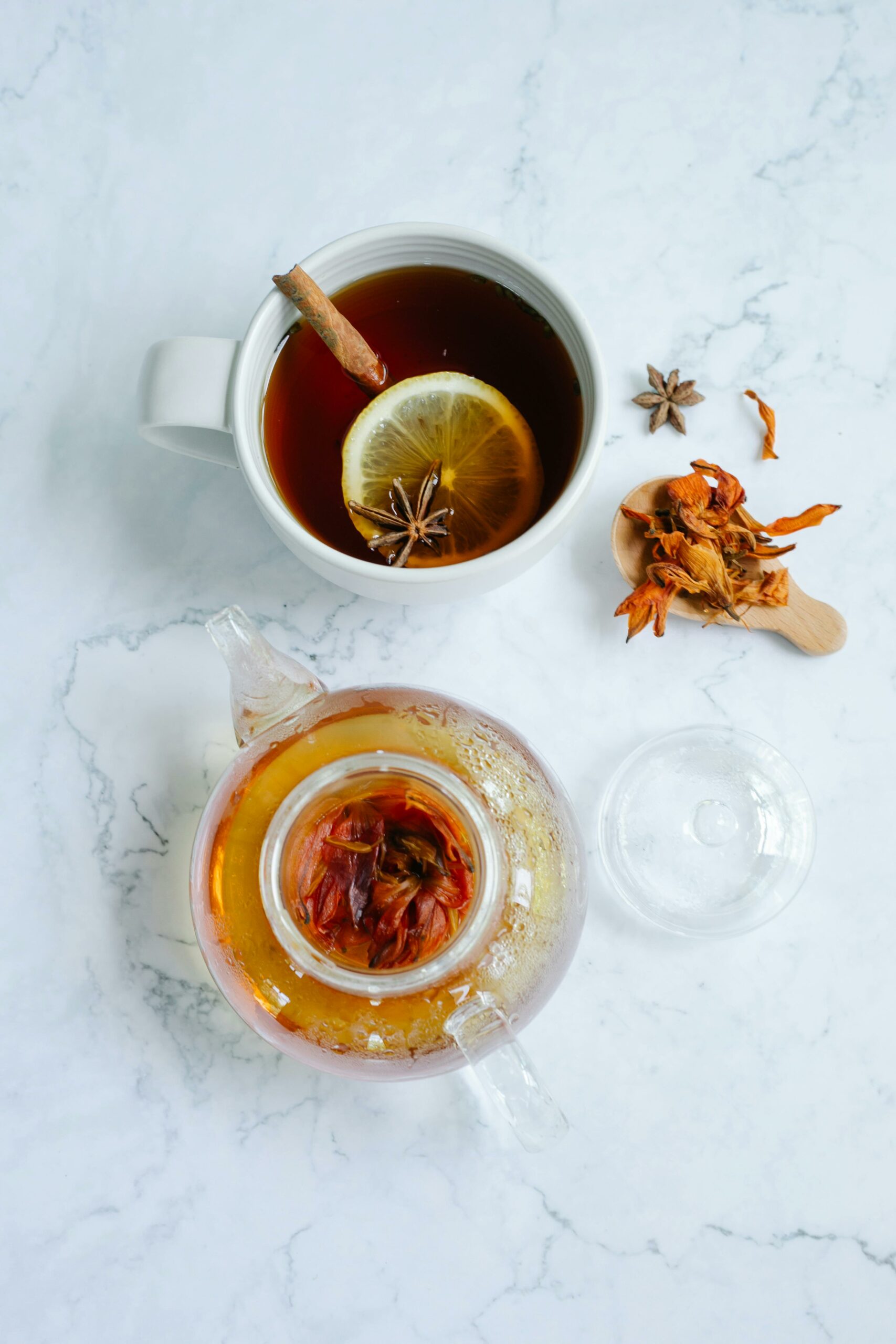 A cozy flat lay of herbal tea with cinnamon sticks and citrus slice, perfect for relaxation and wellness.